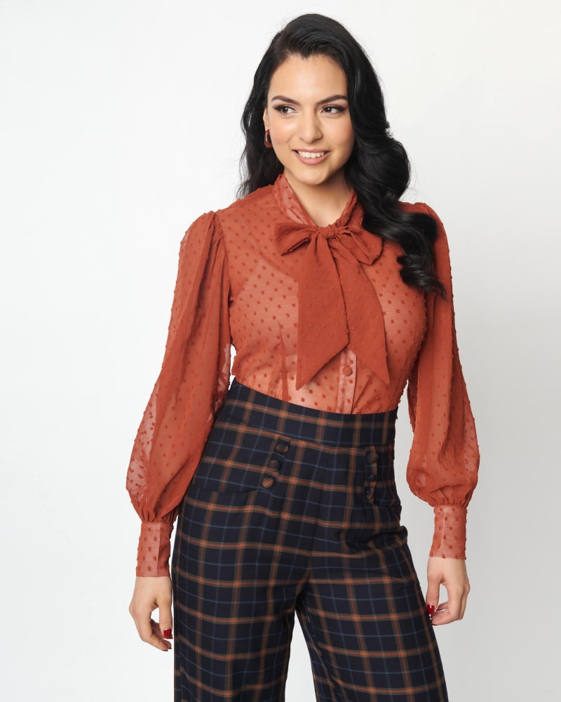 Side of a model wearing a size 2X Unique Vintage Rust Clip Dot Gwen Blouse in Rust Clipdot by Unique Vintage. | dia_product_style_image_id:306010